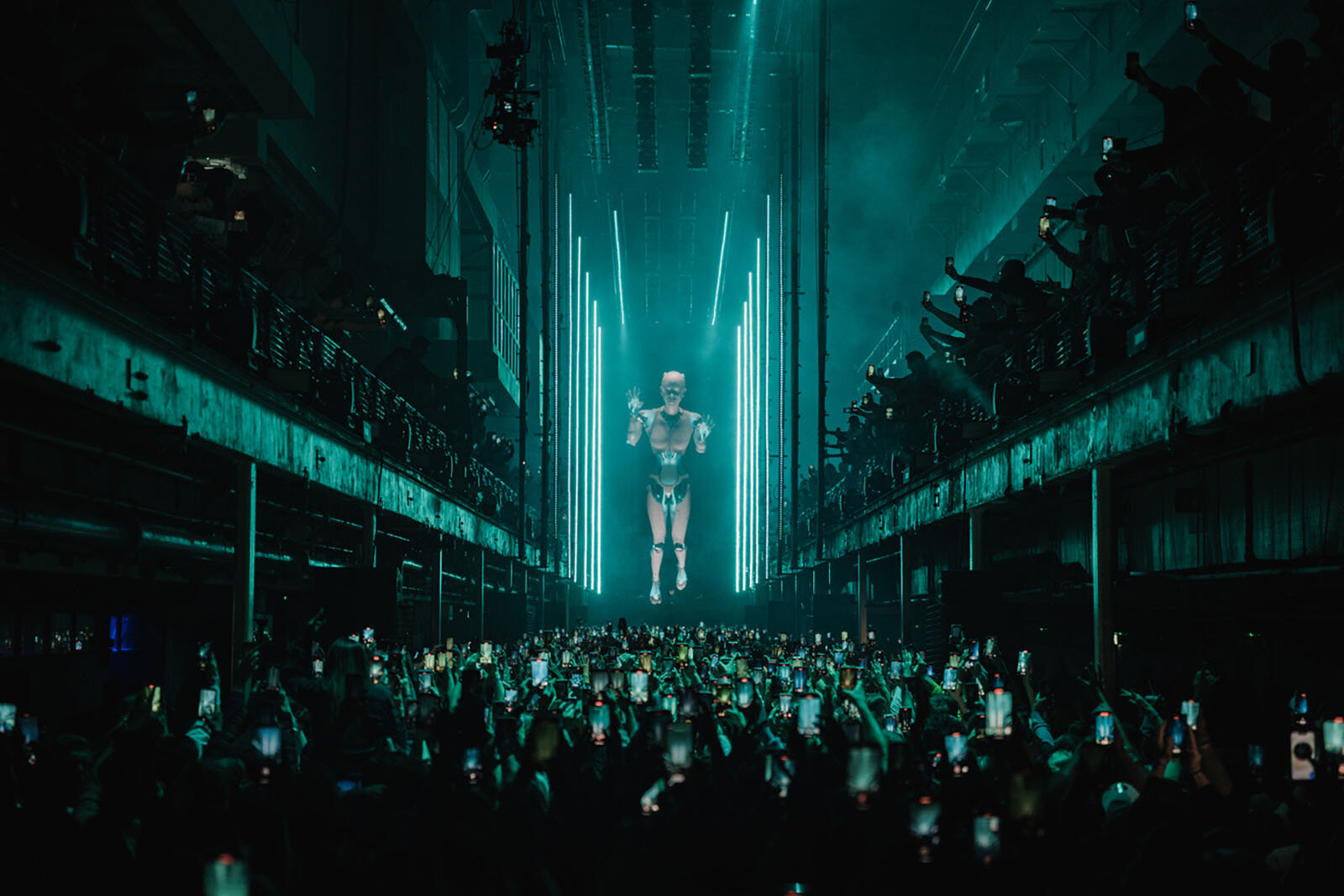 A towering humanoid CGI figure floats above the crowd during Anyma's audiovisual show at Afterlife Printworks