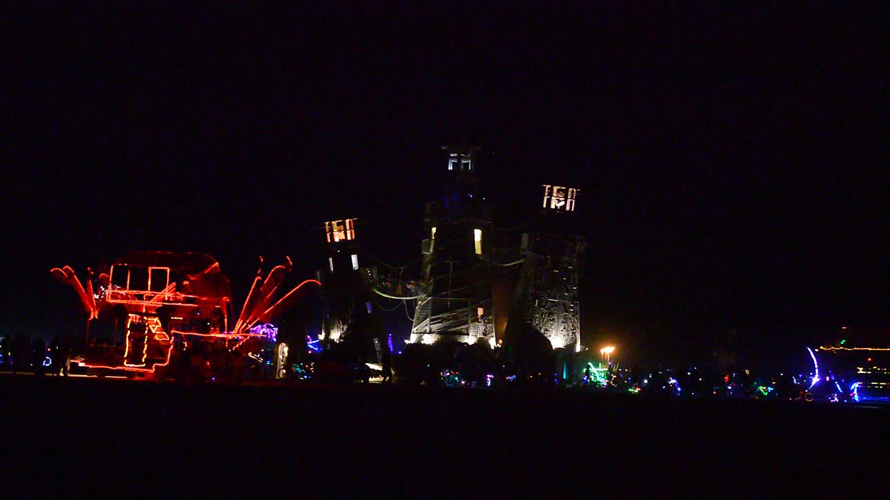 Illuminated art cars gather on the open playa after dark, the kind of mobile sound-system culture that TRION and ¡AXOLOTL! join in 2026. Photo: Bureau of Land Management Nevada via Wikimedia Commons (CC BY 2.0, public domain work of a federal employee).