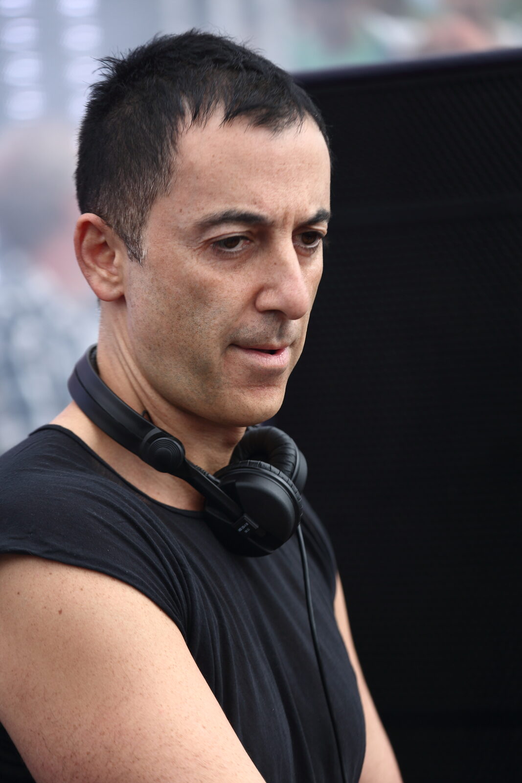 Dubfire looking down in a black sleeveless top with headphones around his neck at Echelon Festival in 2014