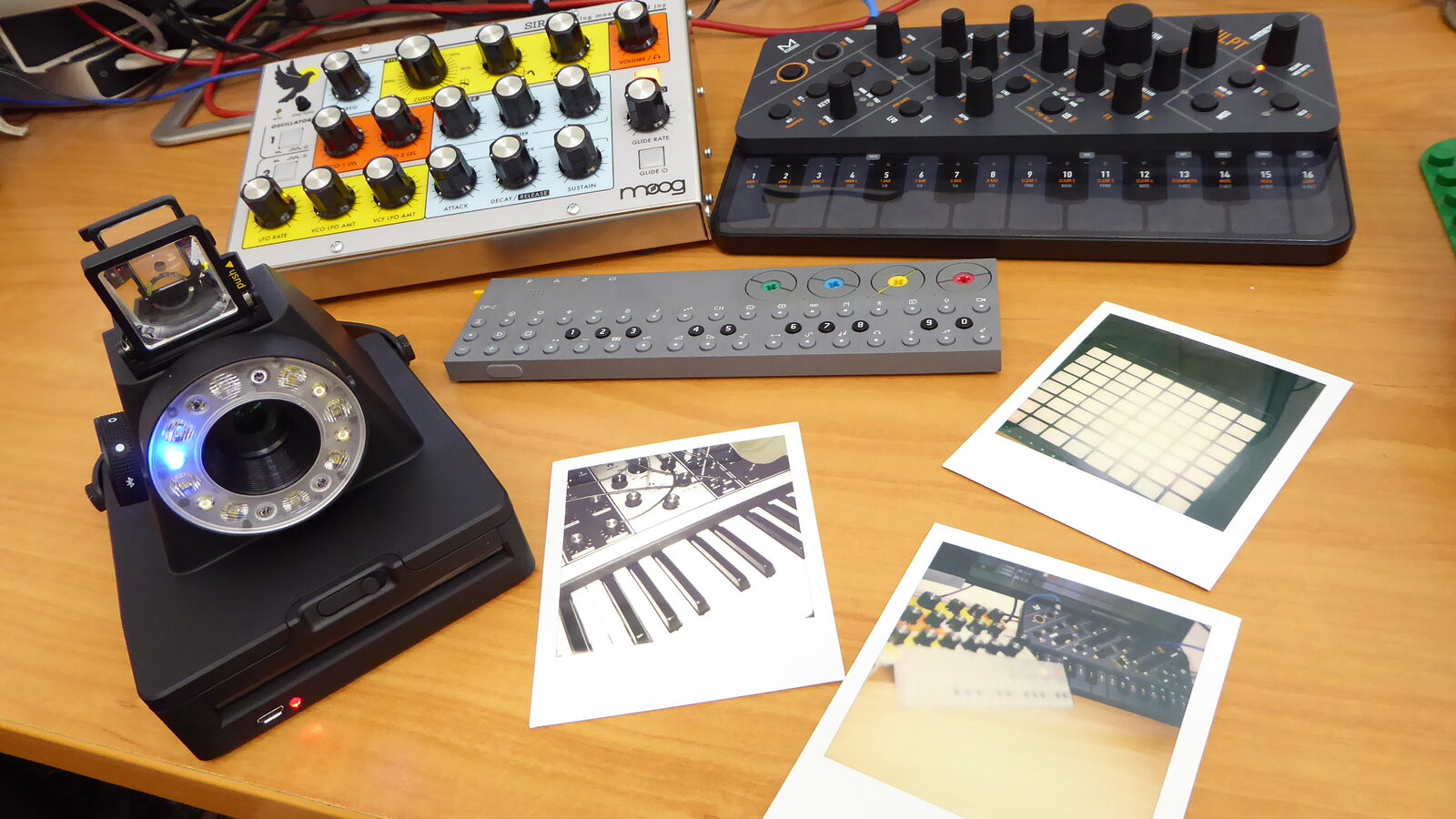 The Impossible I-1 instant camera, one of Teenage Engineering's non-musical designs, photographed next to synthesizers and instant prints