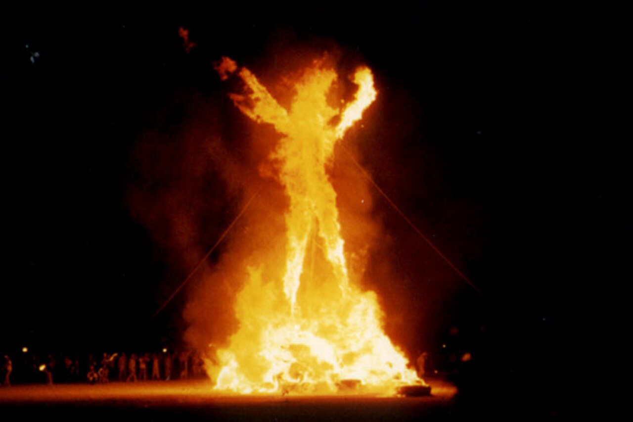 The Man effigy fully ablaze at night during the festival's central burning ceremony.