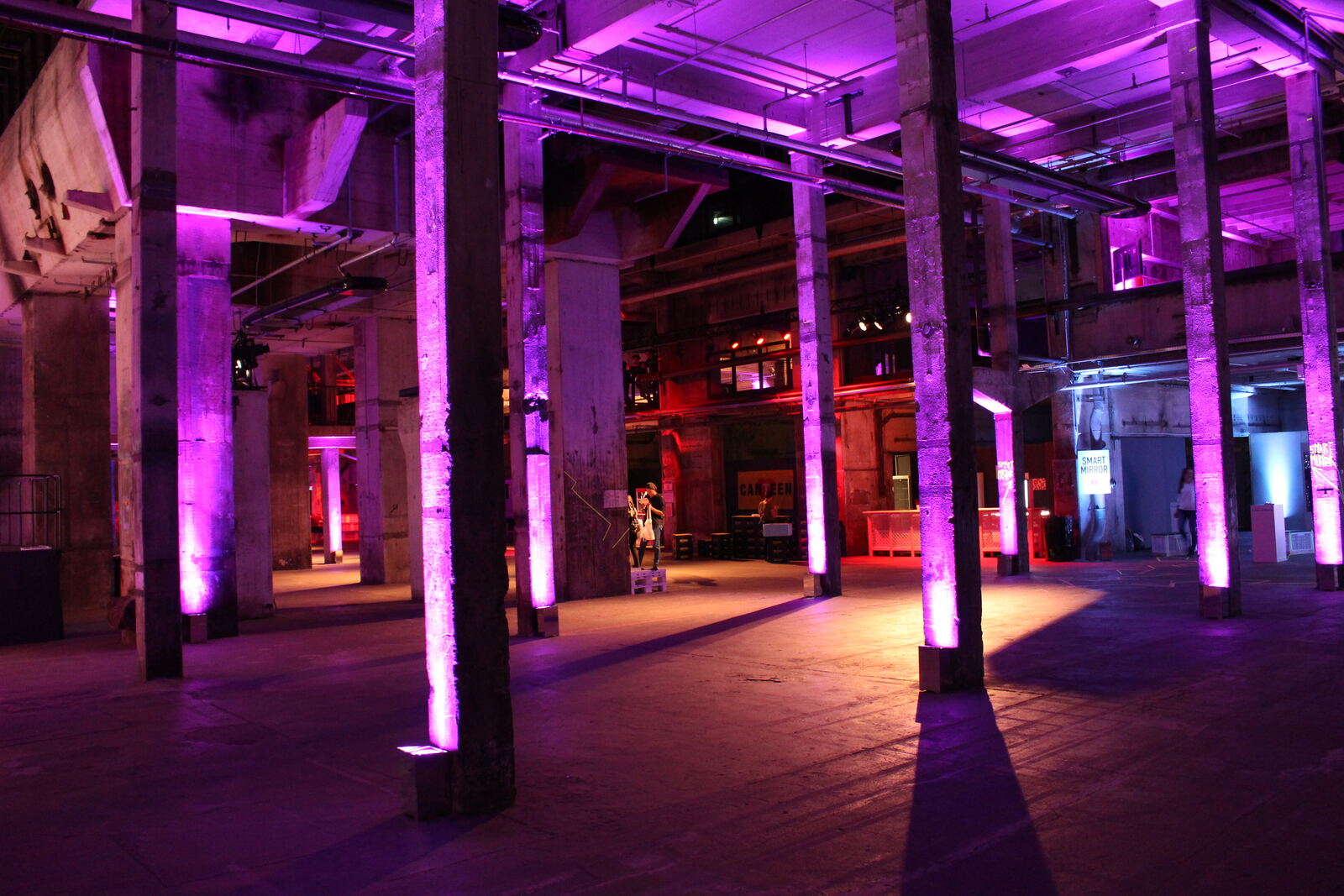 Concrete pillars and turbine hall interior of Kraftwerk Berlin, lit for an event.
