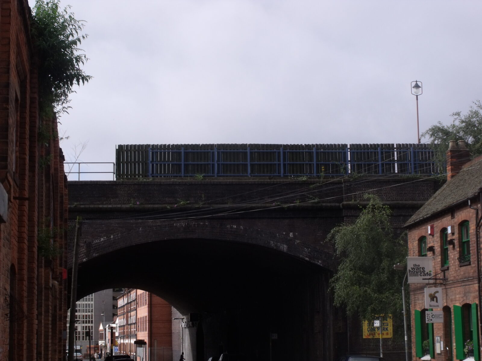 A Victorian railway viaduct arch over a Digbeth street in Birmingham, with the sign of the Ware House Cafe on the right-hand building