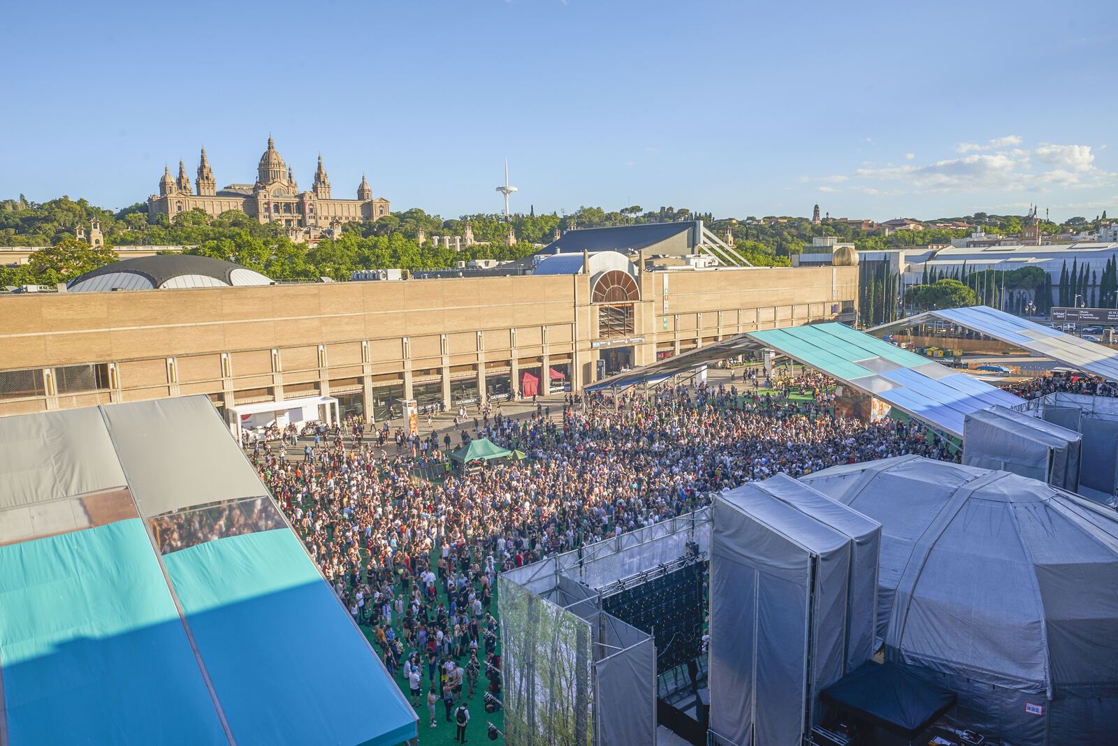 Crowd at Sonar by Day 2016, with the Palau Nacional visible behind the stages at Fira Montjuic, Barcelona.