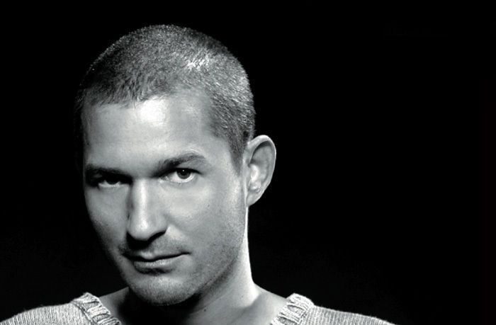 Black-and-white close-up portrait of Terry Lee Brown Jr. with a closely shaved head, wearing a knit sweater against a dark background